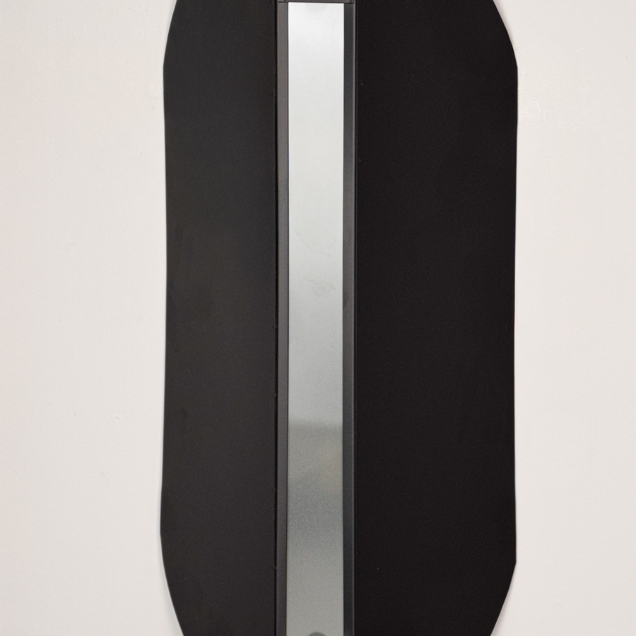 Wall light closeup highlighting smooth black metal finish with soft glowing center showcasing premium craftsmanship and architectural design.
