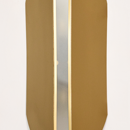 Wall light closeup highlighting smooth gold metal panels with soft glowing center showcasing premium craftsmanship and elegant architectural form.