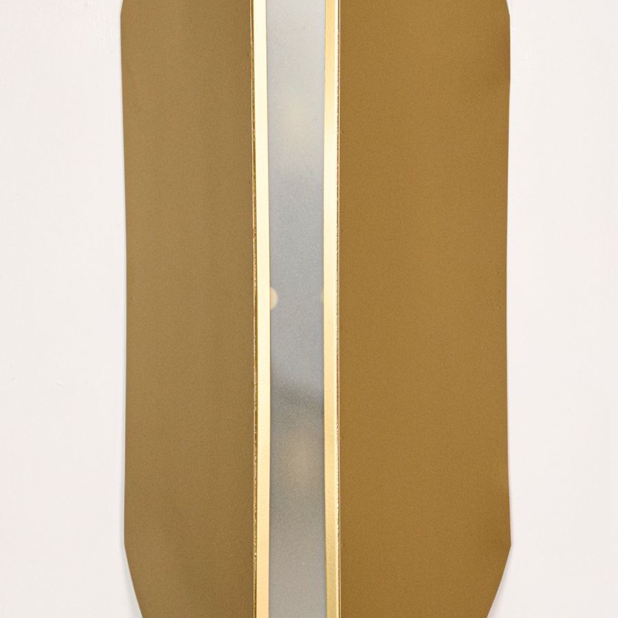 Wall light closeup highlighting smooth gold metal panels with soft glowing center showcasing premium craftsmanship and elegant architectural form.