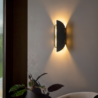 Wall light styled on textured grey wall beside window and indoor plant casting warm upward glow for modern luxury Decor ambience.
