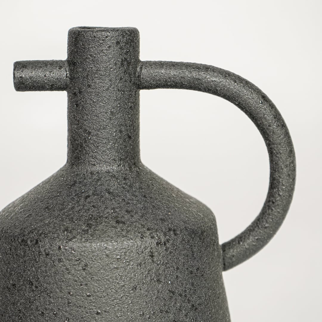 Black ceramic decorative vase with textured stone finish and handle design perfect for elegant dried floral display and interior decor.