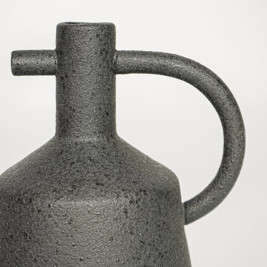 Black ceramic decorative vase with textured stone finish and handle design perfect for elegant dried floral display and interior decor.