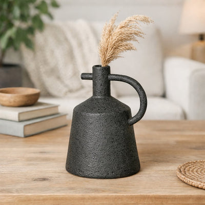 Black ceramic decorative vase with sculpted handle design perfect for dried flower display on console table and modern home decor.