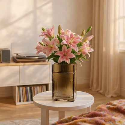 Smoke grey glass decorative vase styled with pink flowers on a side table for elegant modern home decor settings.