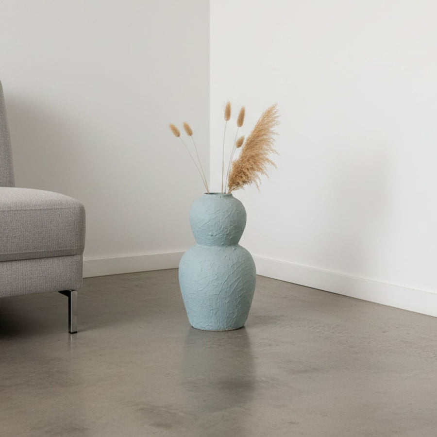 Light blue textured decorative vase arranged in a styled interior adding sculptural artistic decor to living rooms entryways and designed spaces.