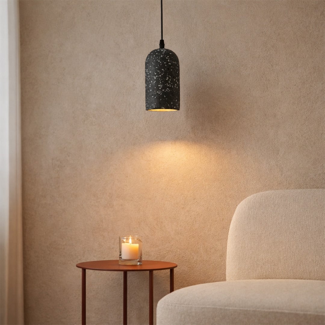 Black terrazzo pendant light with speckled texture adding sophisticated warmth to cozy interiors.