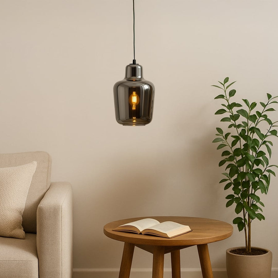 Modern smoked-glass pendant light styled in a warm lifestyle setting showcasing its reflective finish and elegant rounded silhouette.