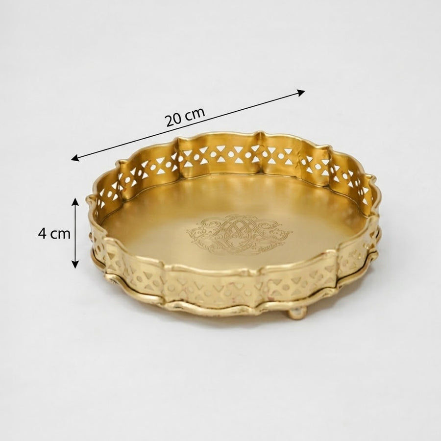 Antique gold metal serving tray with pierced scalloped edges and engraved center designed for elegant table decor.