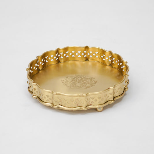 Antique gold metal serving tray with scalloped edges and intricate detailing designed for festive table decor.