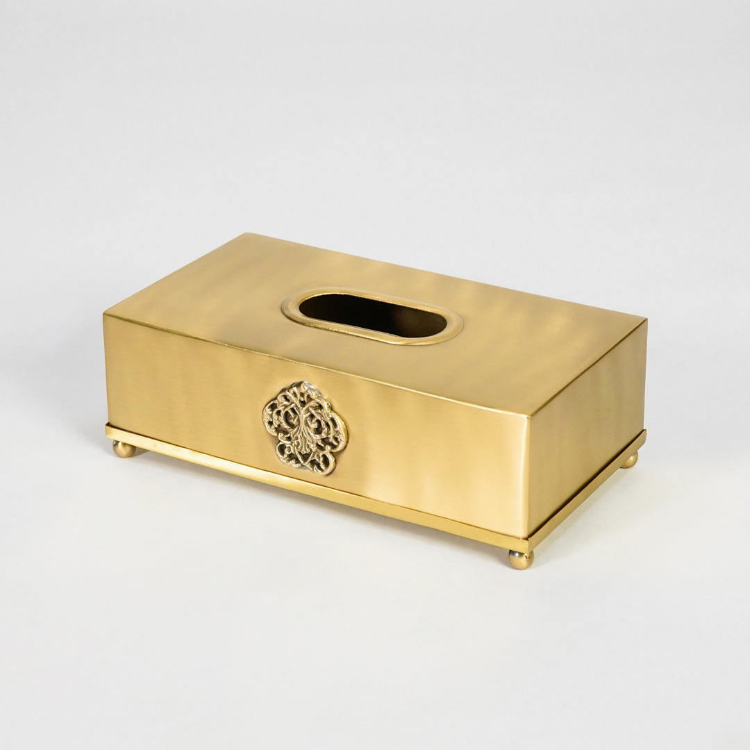 Antique gold rectangular tissue box holder with decorative emblem and smooth finish for sophisticated interiors.