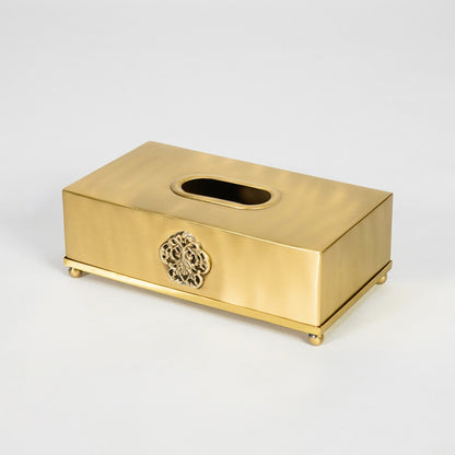 Antique gold rectangular tissue box holder with decorative emblem and smooth finish for sophisticated interiors.