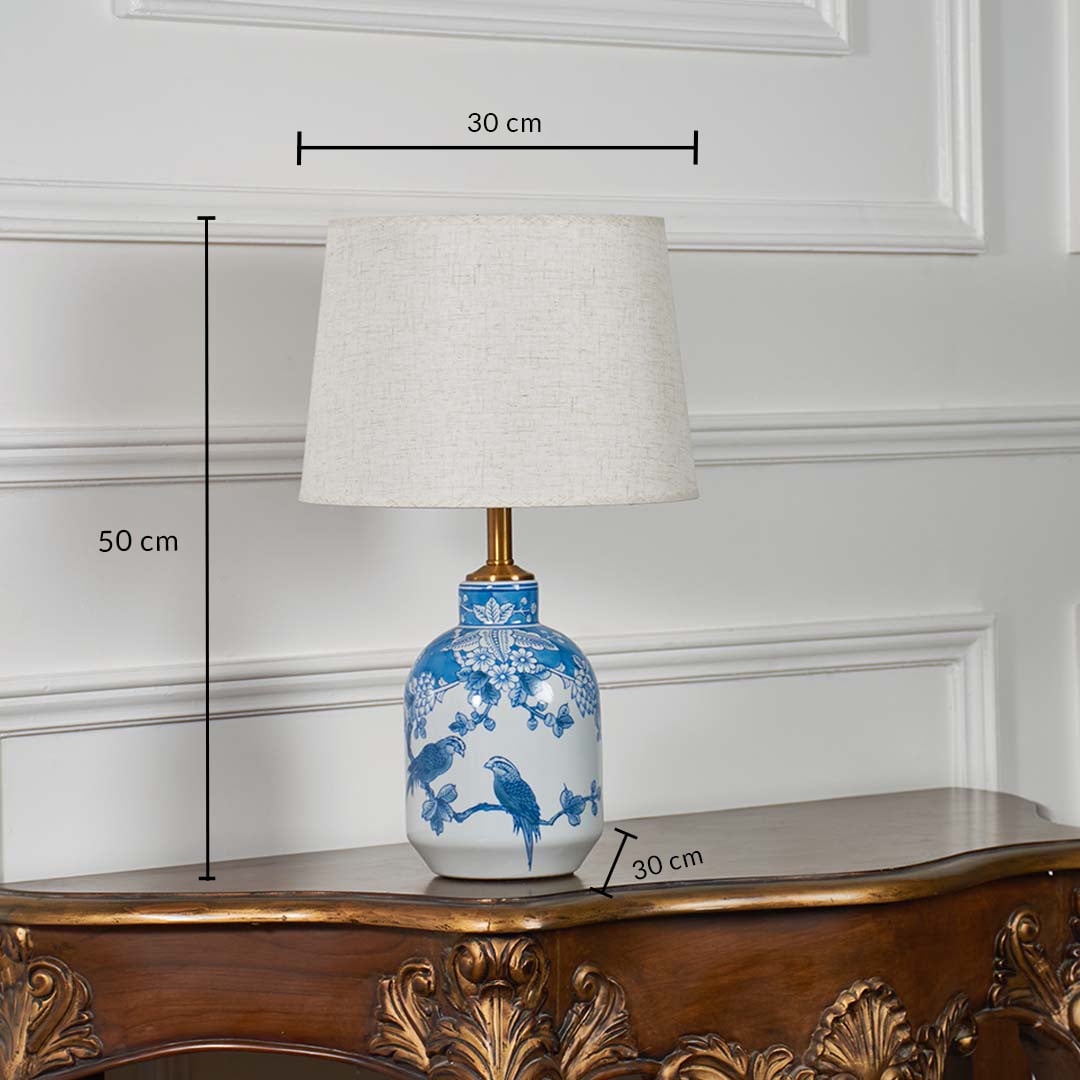 Blue and white ceramic table lamp with cream shade shown with measurements of 50 cm height and 30 cm width on a wooden console.