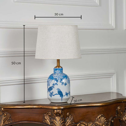 Blue and white ceramic table lamp with cream shade shown with measurements of 50 cm height and 30 cm width on a wooden console.