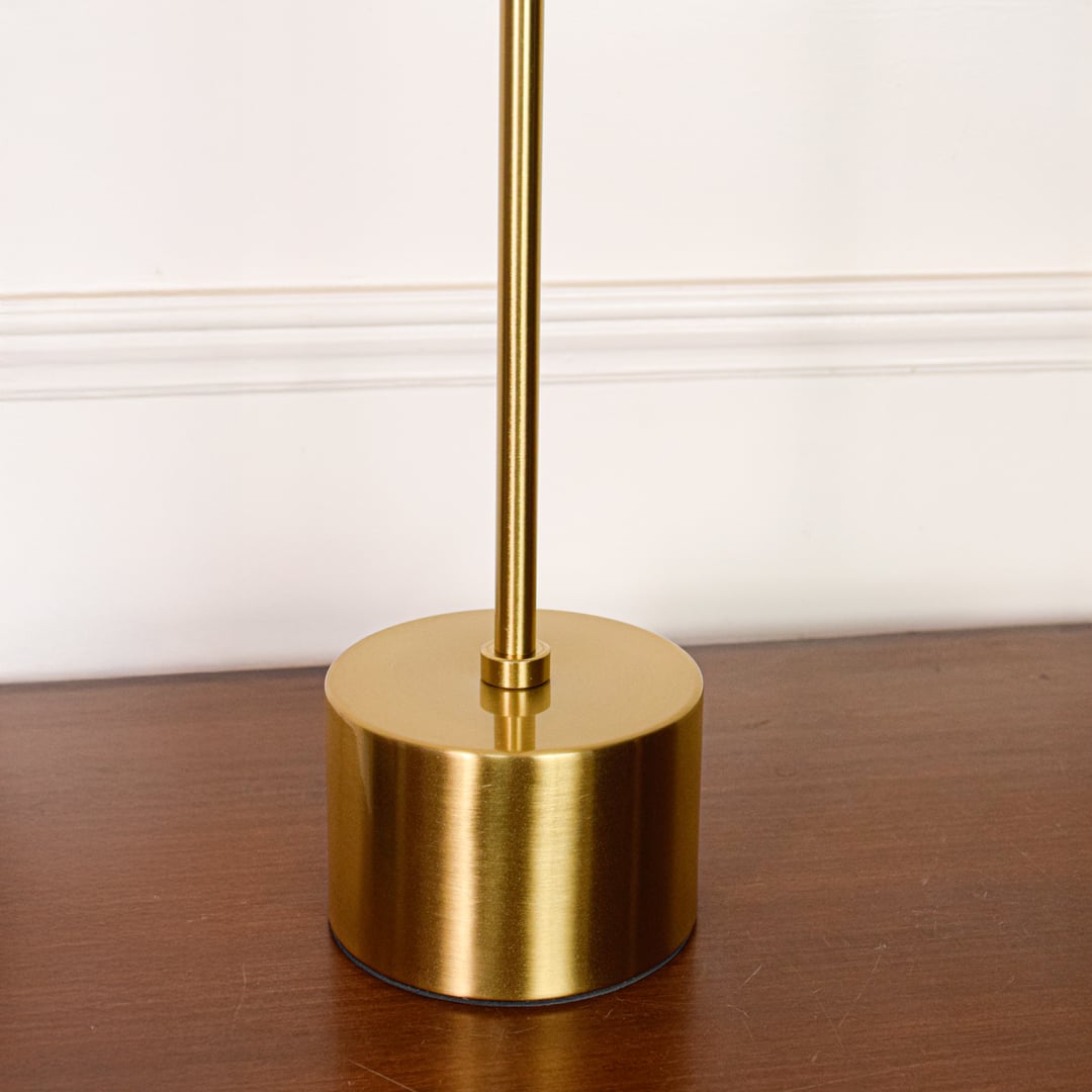 Closeup of gold metal desk lamp showing smooth metal finish wooden light tube and precision joint detailing.