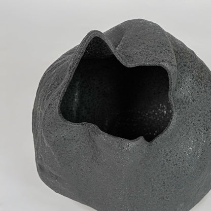 Closeup black textured ceramic vase surface detail modern decorative flower vase for table shelf console decor.