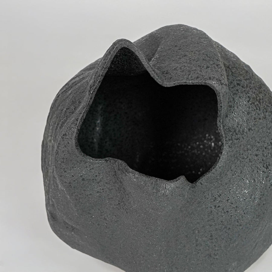 Closeup black textured ceramic vase surface detail modern decorative flower vase for table shelf console decor.