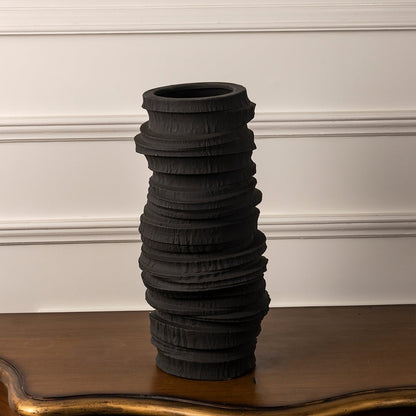Tall black ceramic vase with sculptural layered texture shown on white background for modern decor inspiration.