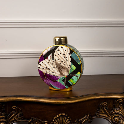 Butterfly design ceramic jar on a plain white background focusing on its round shape and striking color contrast.
