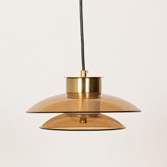 Amber and smoky grey glass pendant lights with gold metal fittings shown with lights off highlighting their layered contemporary shade design.