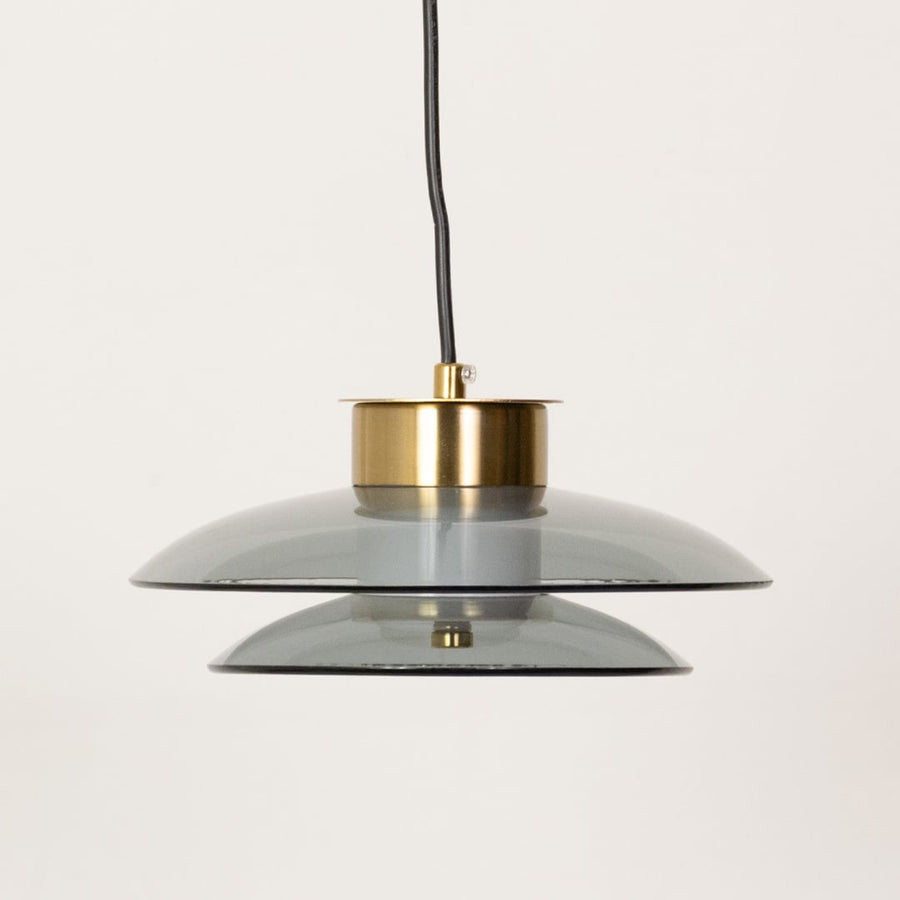 Pair of grey and amber pendant lights shown with lights off highlighting the layered glass design and contemporary round form.