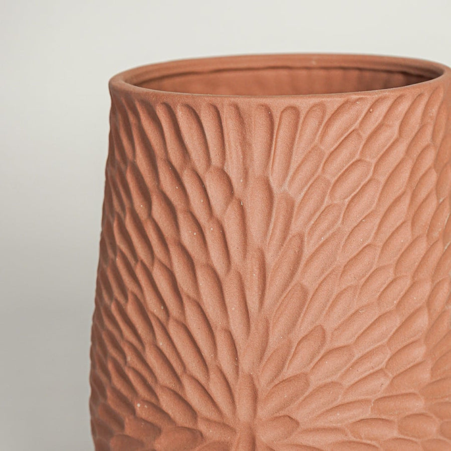Close view of green textured ceramic double tube vase highlighting ribbed surface finish and sculptural modern decor style.