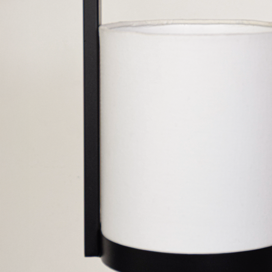 Closeup of black metal pendant light with white fabric shade for elegant modern lighting decor styling ideas.