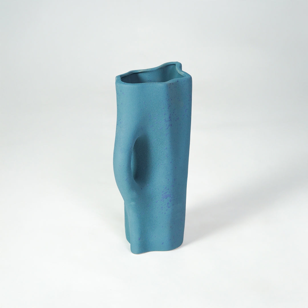 White background image of blue ceramic decorative vase for elegant shelf placement with textured matte finish.