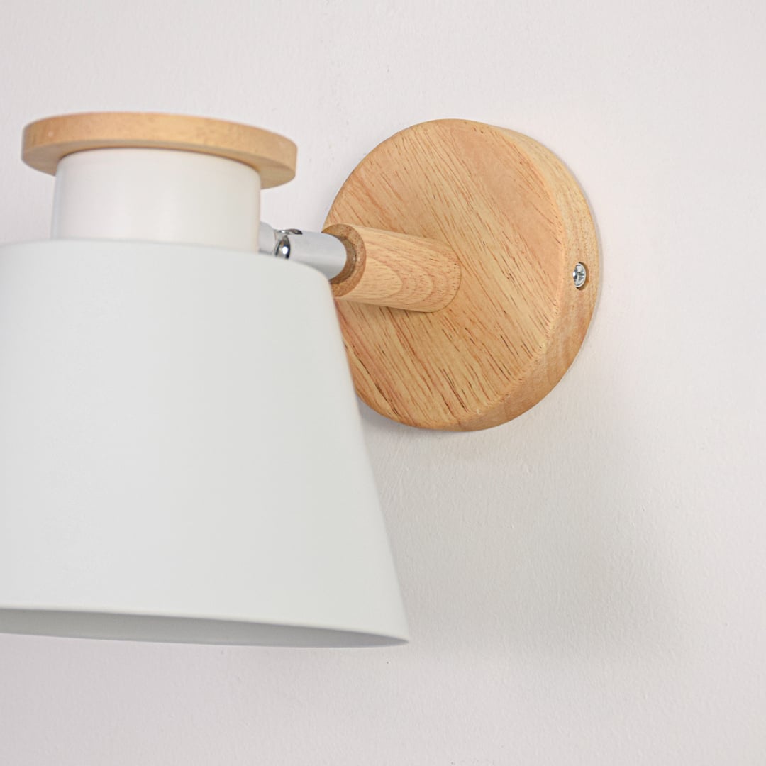 White fabric shade wall light closeup highlighting smooth diffuser and natural wood backplate detail for soft indoor lighting decor.