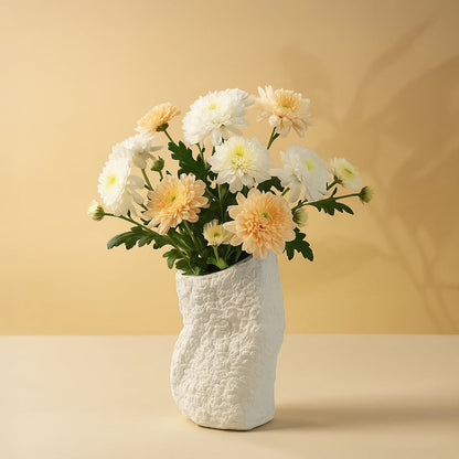 Small round black textured ceramic vase styled with dried pampas and protea flowers placed on a vintage wooden dresser.