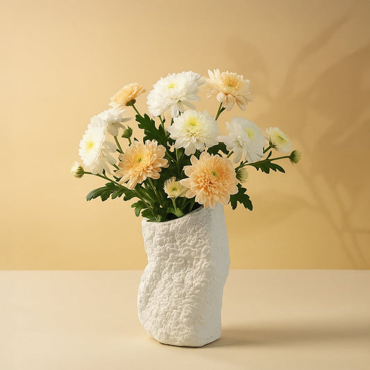 Small round black textured ceramic vase styled with dried pampas and protea flowers placed on a vintage wooden dresser.