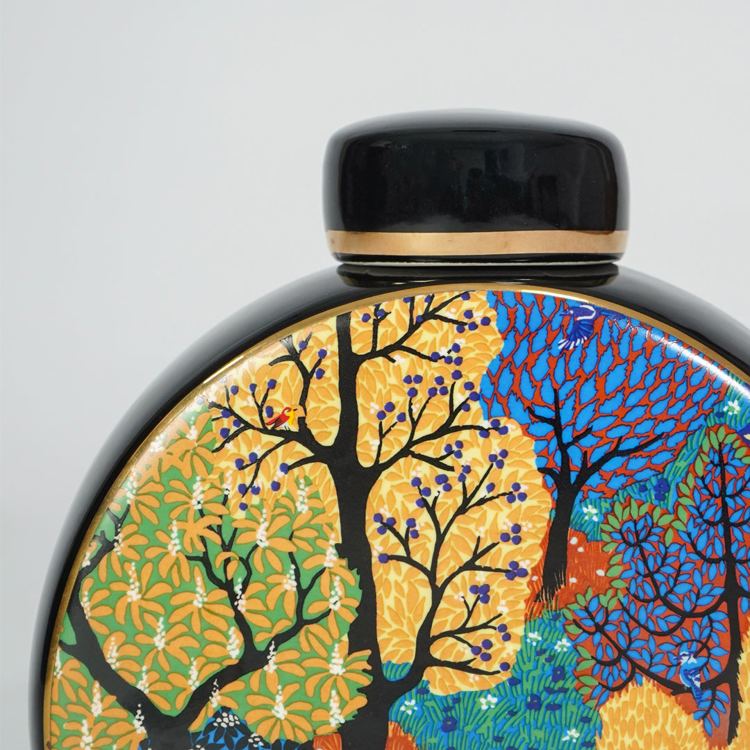 Closeup of round ceramic decorative jar with colorful tree artwork showcasing premium craftsmanship and artistic styling.