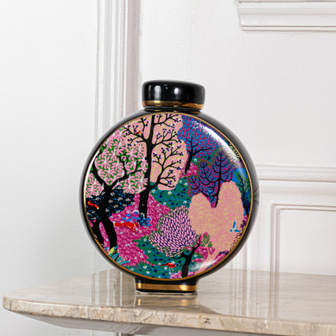 Round ceramic decorative jar with colorful tree artwork displayed on a console table for elegant home decor styling.