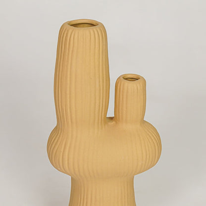 Closeup of mustard ceramic vase with ribbed textured finish for elegant shelf and tabletop decor styling ideas.