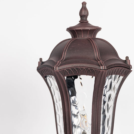 Closeup of antique brown pillar light showing patterned clear glass and vintage detailing for stylish outdoor lighting design.