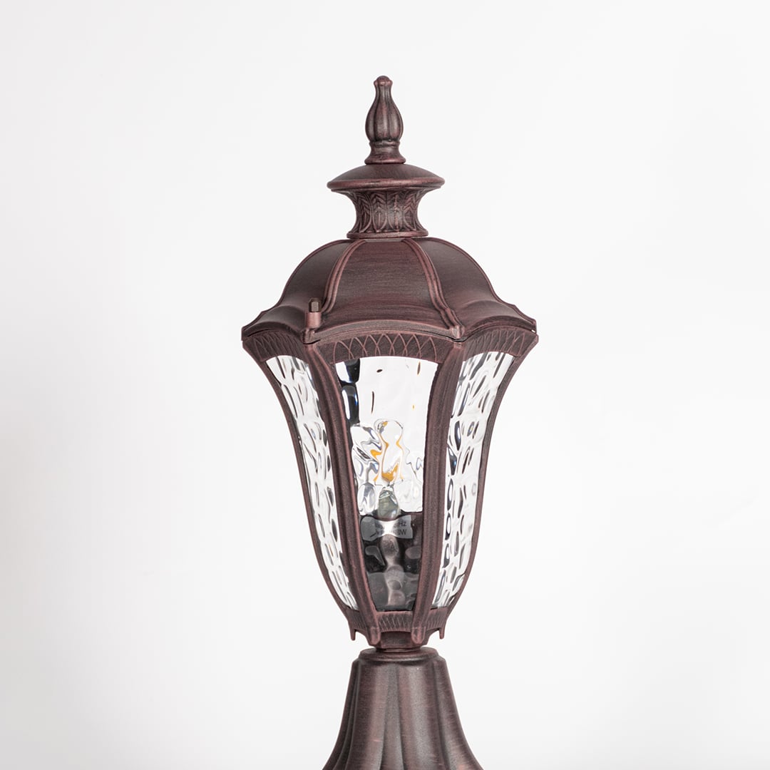 Closeup of antique brown pillar light showing detailed patterned glass and vintage design for classic exterior lighting.