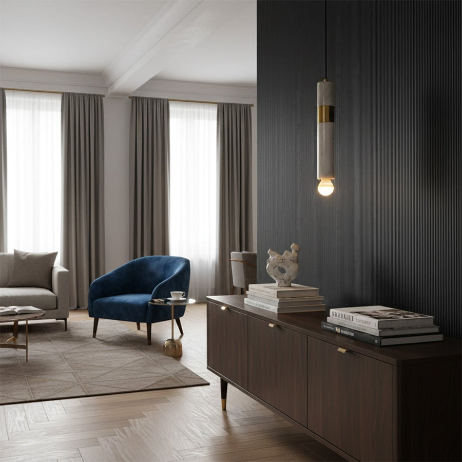 Green marble and metal cylinder pendant light with exposed bulb hanging in modern living room with light on for elegant contemporary décor.