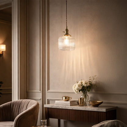 Textured clear glass and brass metal pendant light adding warm charm to cozy bedroom interiors.