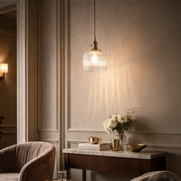Textured clear glass and brass metal pendant light adding warm charm to cozy bedroom interiors.