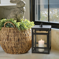 Lifestyle image of small black metal candle lantern for rustic patio decor styling and modern outdoor home garden lighting.