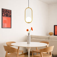 Gold metal oval pendant light suspended above dining table adding modern luxury to contemporary dining space.