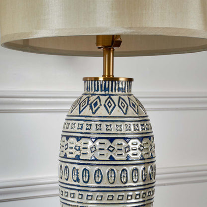 Closeup view of the ceramic lamp base showing intricate blue detailing and glossy texture with the neutral shade adding a classic elegant finish.