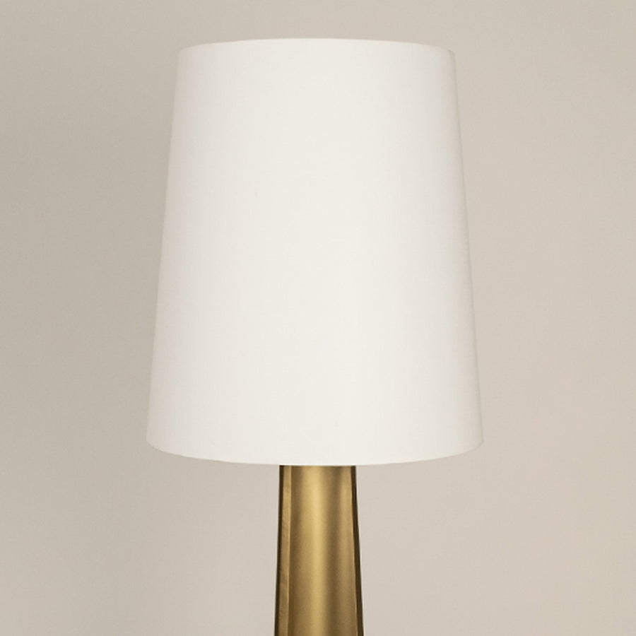White fabric drum shade with brass metal stem showcasing refined craftsmanship and timeless contemporary design appeal.