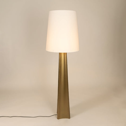 Modern floor lamp with tall metal base and wide white tapered shade glowing softly against a clean white background showcasing minimalist interior home decor lighting style.