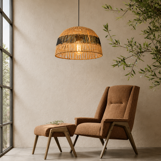 A warm, bohemian-style woven rattan pendant light hangs over a matching upholstered armchair and ottoman in a minimalist room with a textured beige wall and a window on the left.