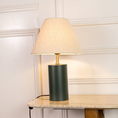 Green metal table lamp with beige fabric shade illuminated on white background ideal for bedroom living room and Decor use.