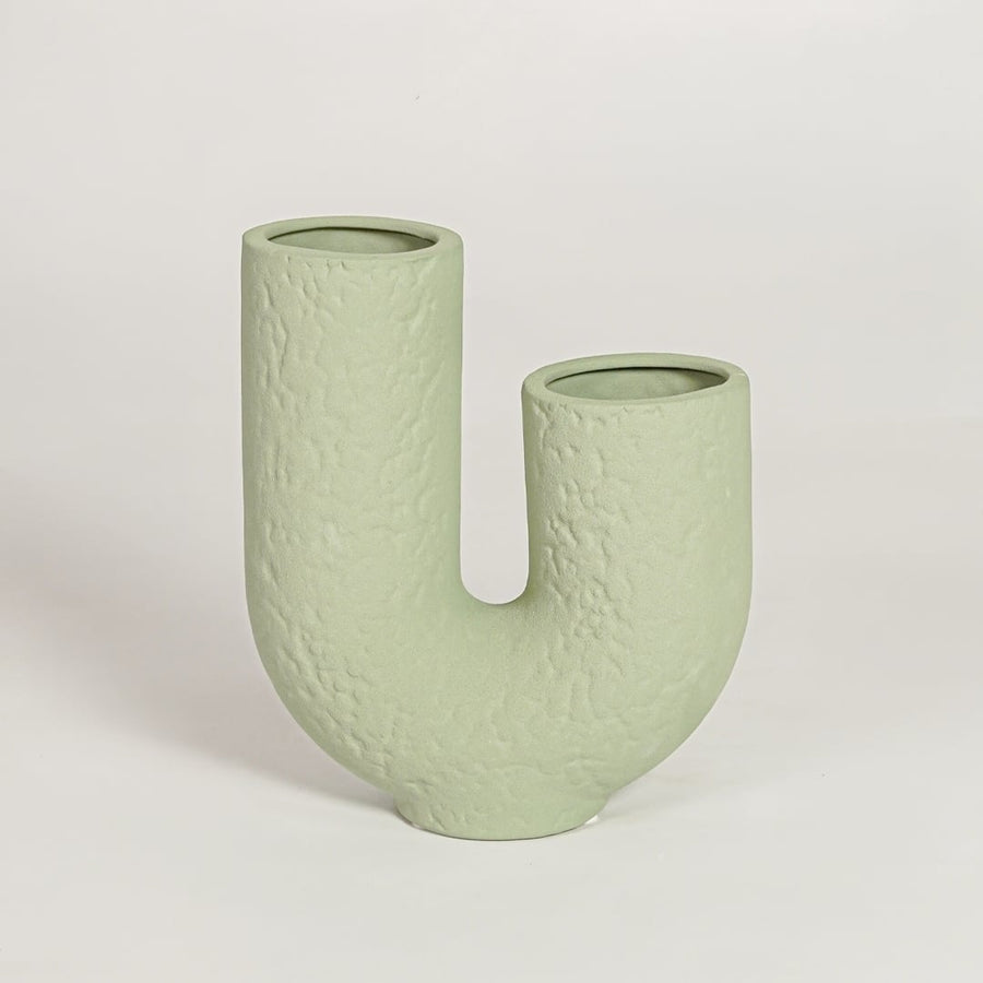 Tuba textured light green ceramic U shaped vase isolated on clean white background for contemporary decor use.