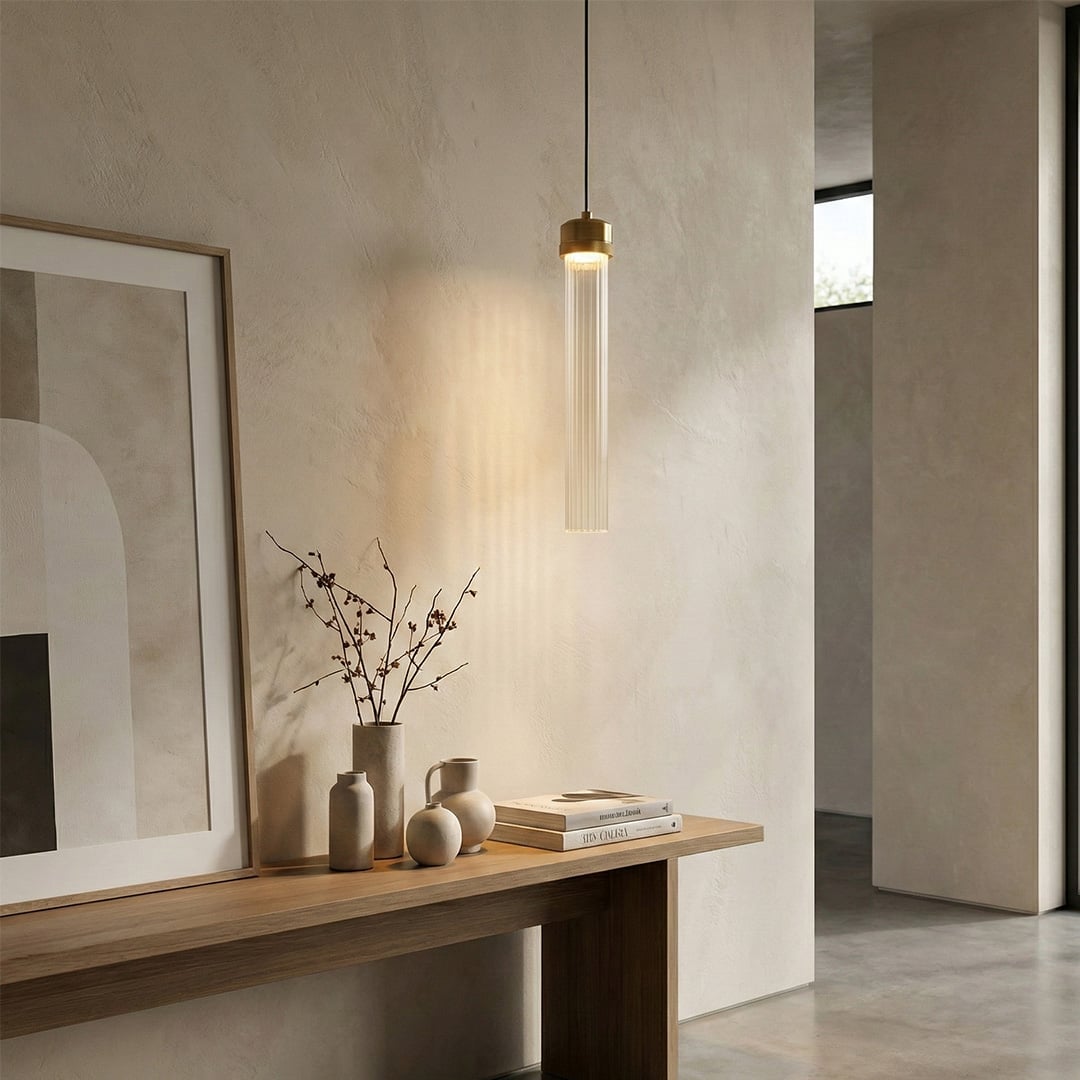Slim gold pendant light above console table adding sophisticated warmth and modern appeal indoors.