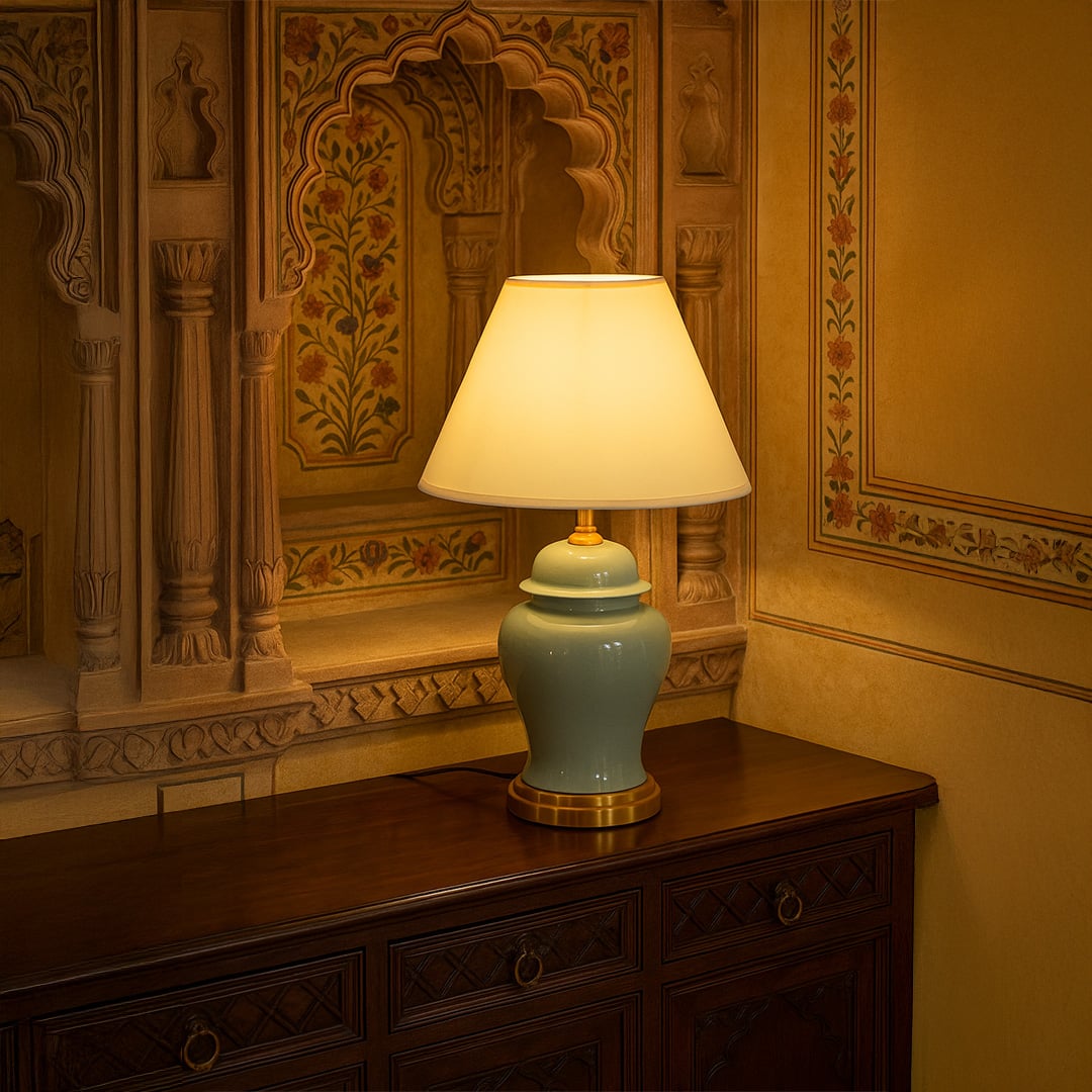Yellow shade green ceramic table lamp on wooden sideboard with light on for warm vintage décor styling.