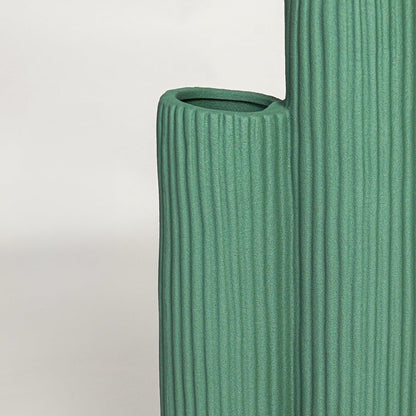 Close view of green ceramic vase showing ribbed texture matte finish and handcrafted modern sculptural design.