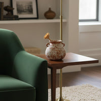Rustic terracotta patterned vase with handles on wooden side table for warm cozy home interior and elegant decor.